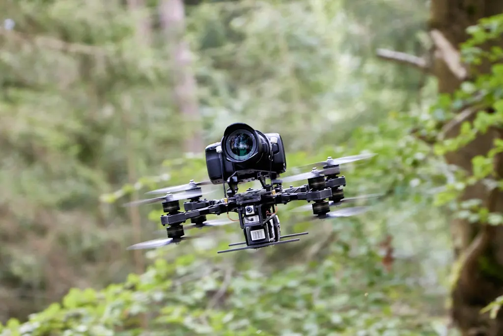 FPV-Heavylifter mit Kinokamera im Flug zwischen Bäumen